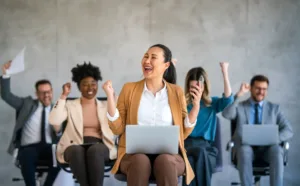 Equipe feliz comemorando um sucesso em um ambiente de trabalho moderno. Profissionais unidos mostram alegria e celebração em reunião corporativa.