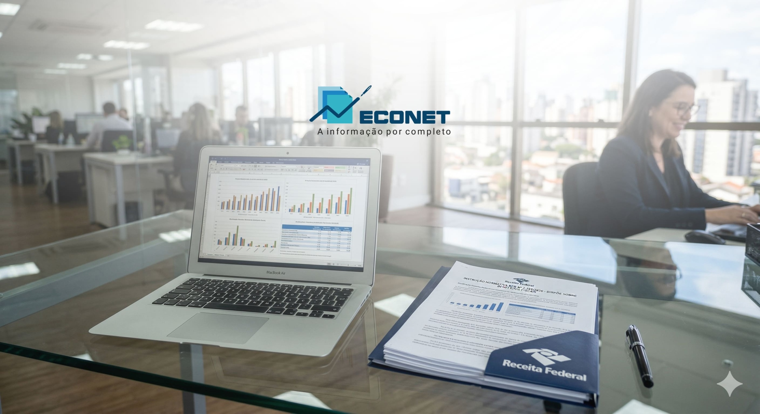 Ambiente de escritório moderno com laptop exibindo gráficos, documentos e receitafederal na mesa, com pessoas ao fundo trabalhando em ambiente corporativo.